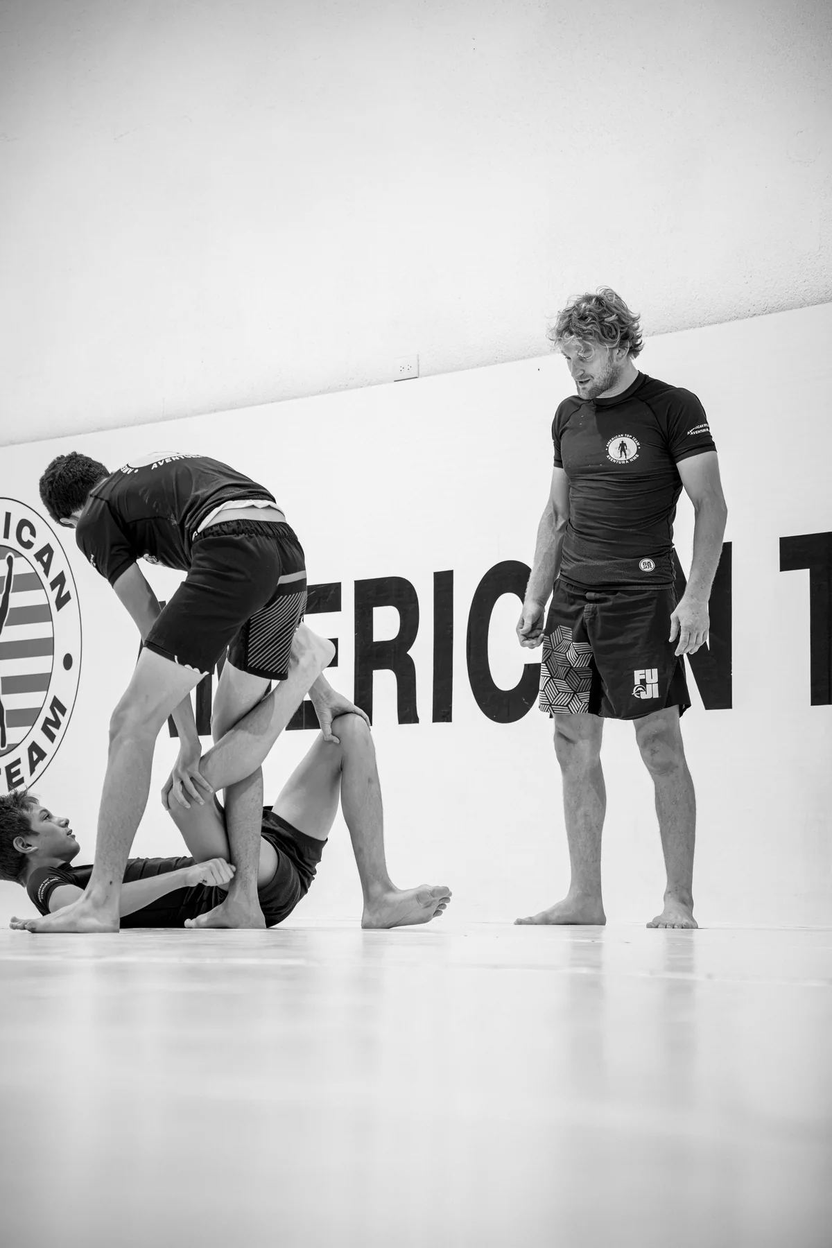 Black-and-white documentary photograph of Brazilian Jiu-Jitsu practice at the academy